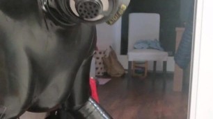 Rubber latex sissy in gasmask plays with dildo